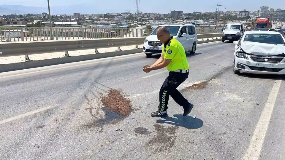 Trafik güvenliğini sağlamak amacıyla yağ dökülen yola avuçlarıyla kum taşıyan polis takdir topladı